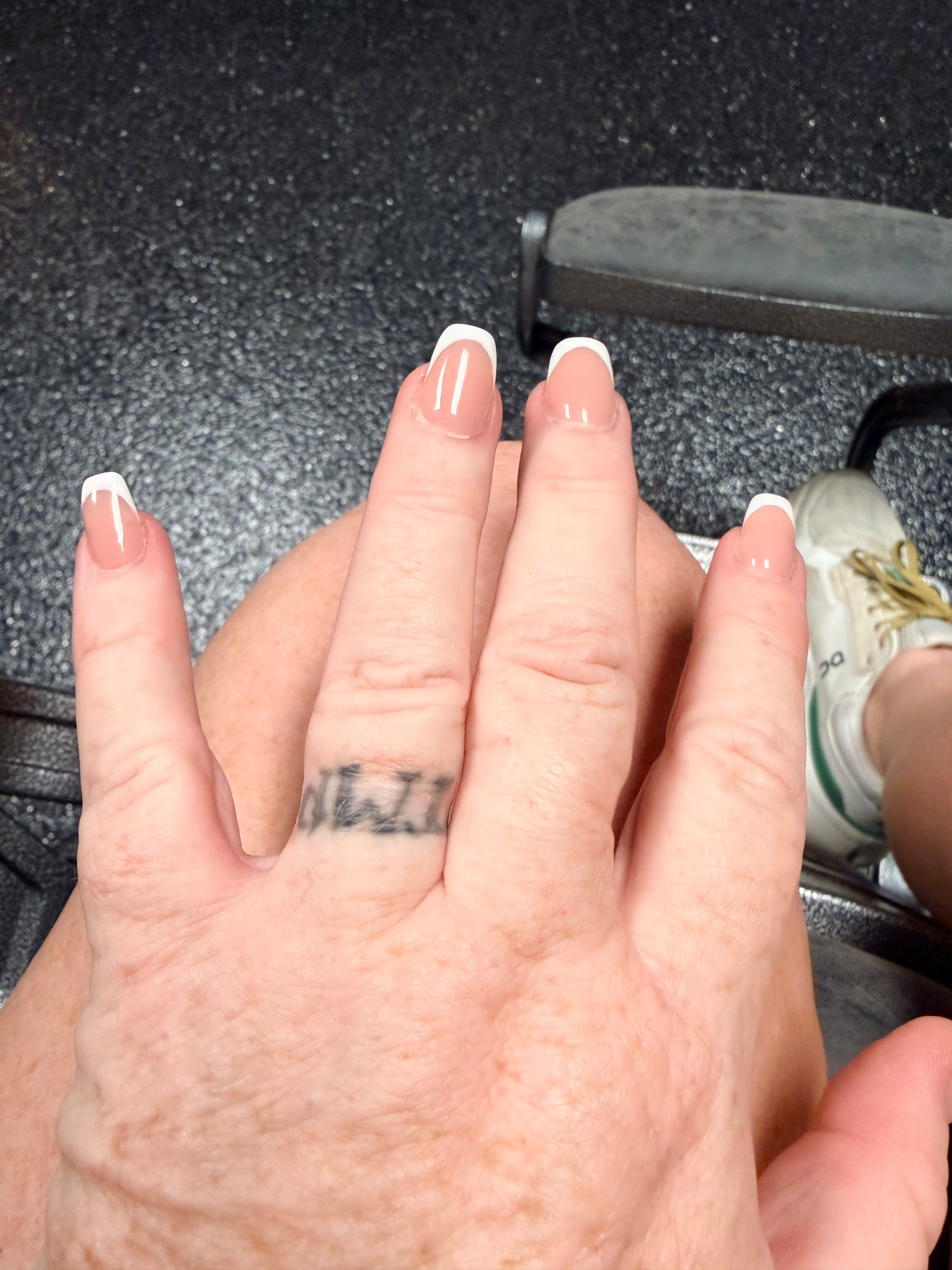Lettering tattoo on a ring finger before laser treatment